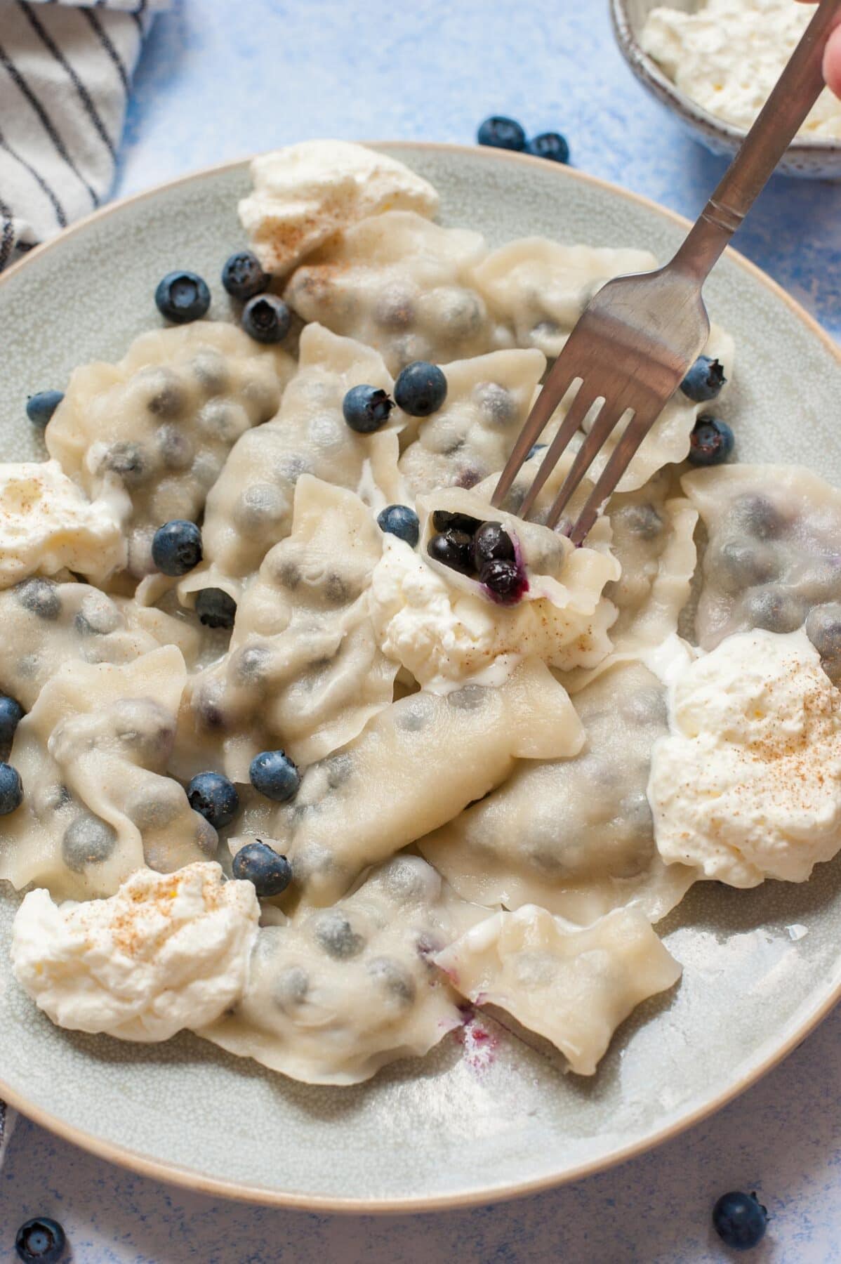 Blueberry pierogi on a blue plate.