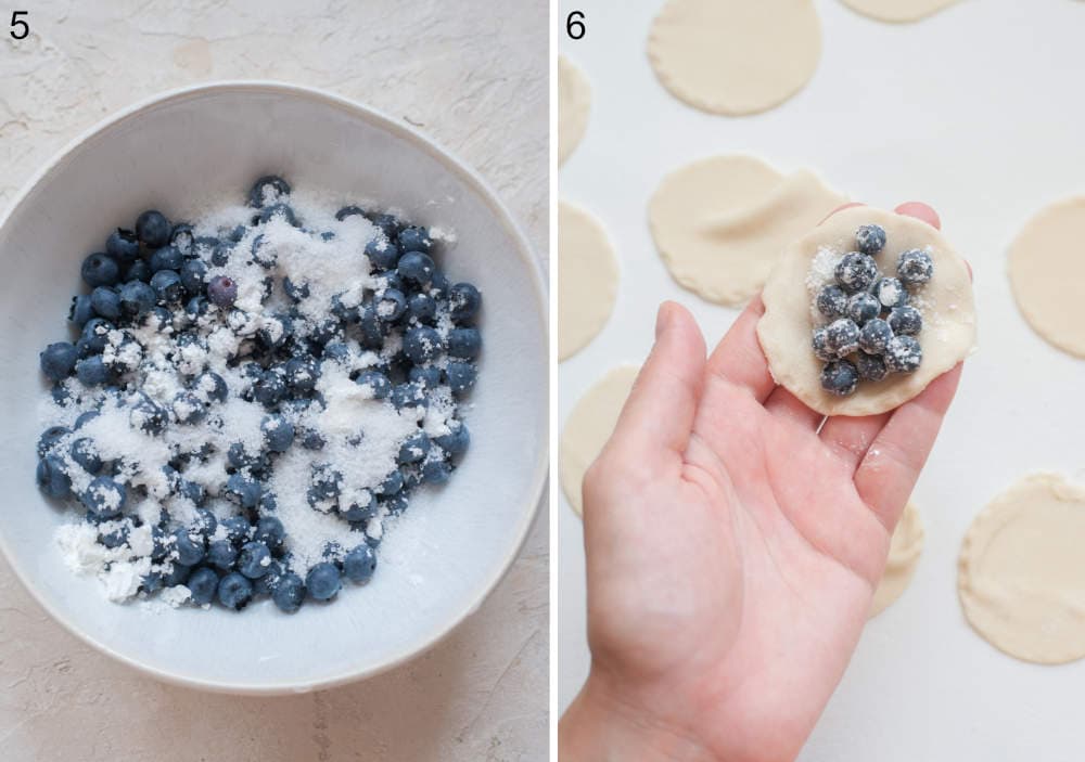 Blueberries with flour and sugar in a bowl. Pierogi dough round with blueberries on top is being held in a hand.