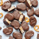 Chocolate peanut butter pretzels on a piece of parchment paper.