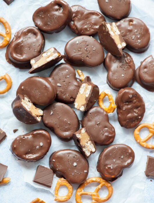 Chocolate peanut butter pretzels on a piece of parchment paper.