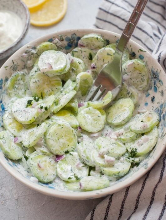 Mizeria (Polish cucumber salad) in a white bowl.