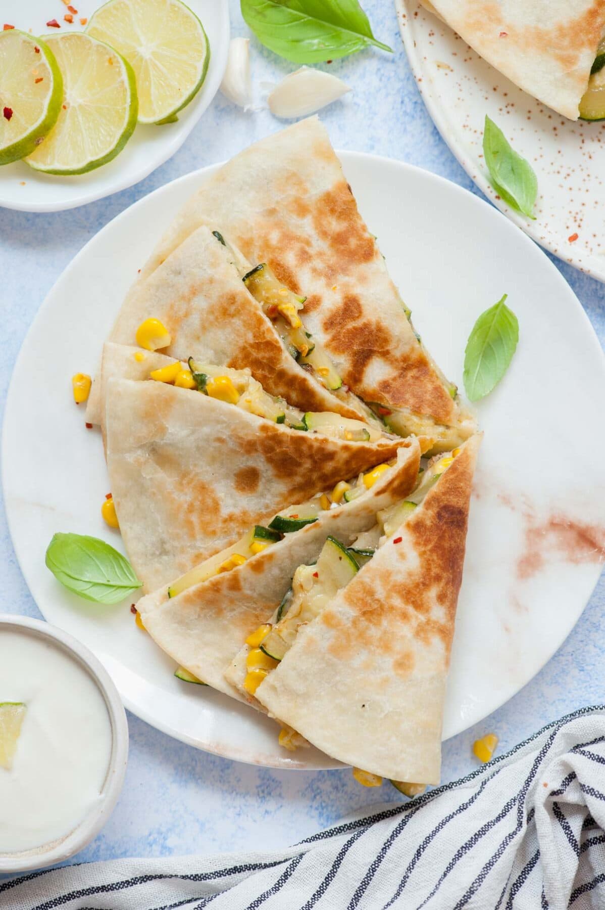 Zucchini quesadilla triangles on a white plate.