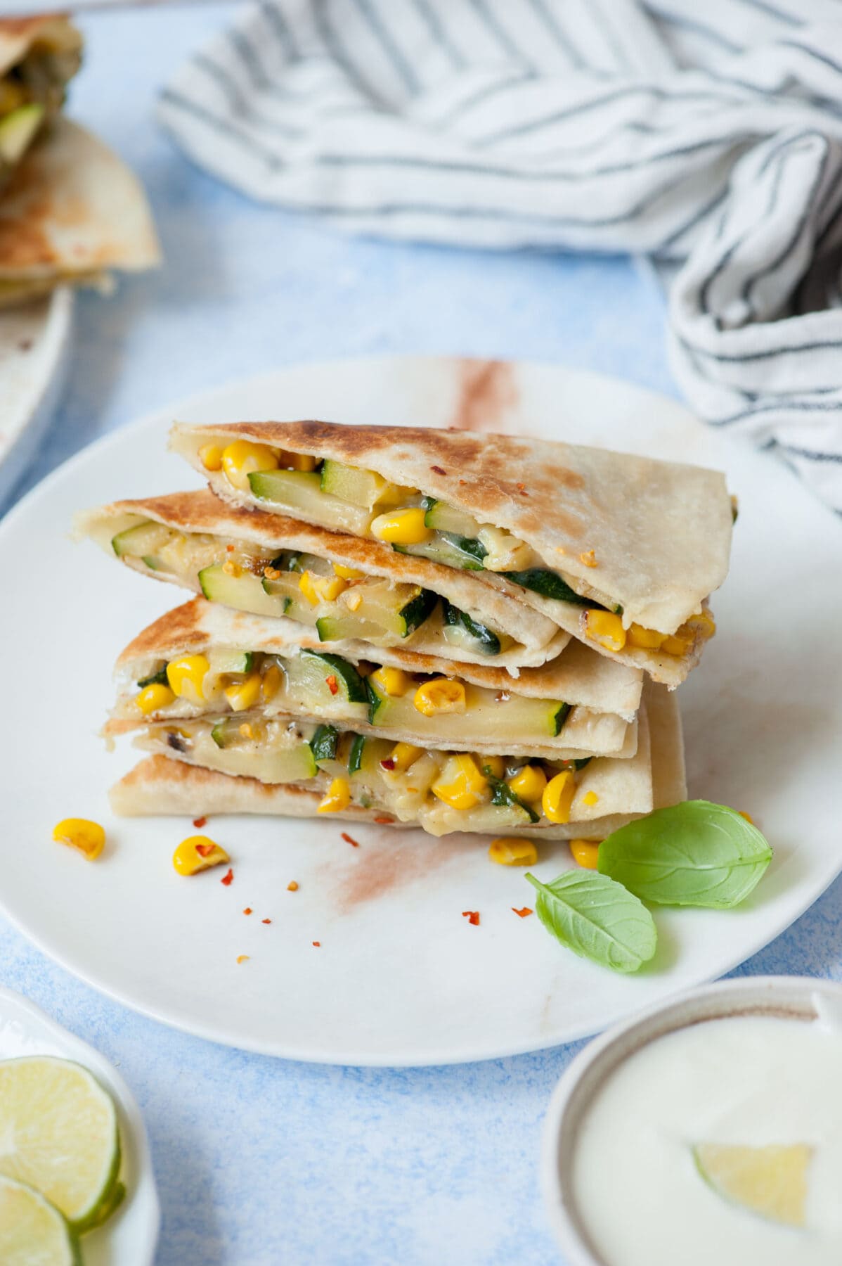 A stack of zucchini quesadilla on a white plate.