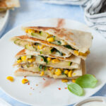 A stack of zucchini quesadillas on a white plate.