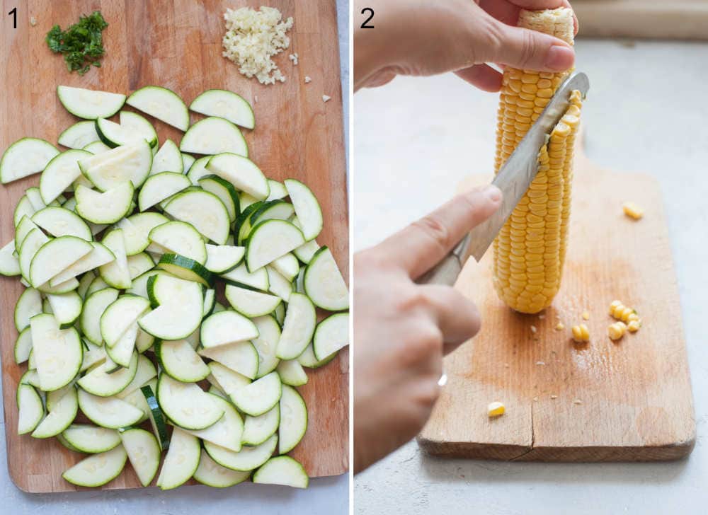 Sliced zucchini, chopped garlic and basil on a chopping board. Corn kernels are being cut off of the cob.