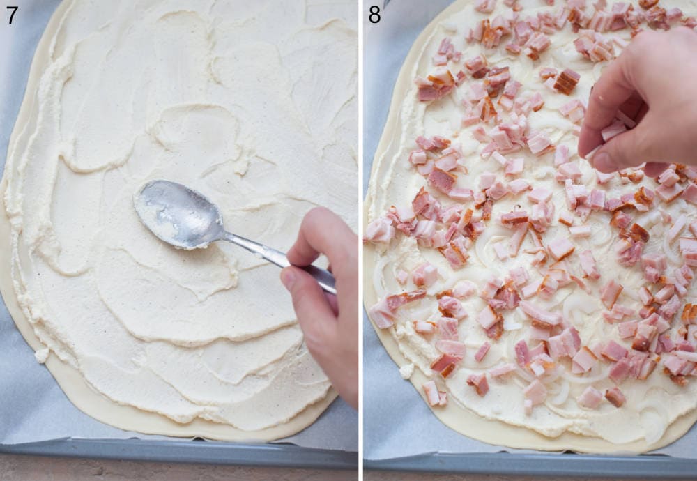 Creme fraiche is being spread with a spoon on a rolled out dough. Flatbread is being topped with chopped bacon.