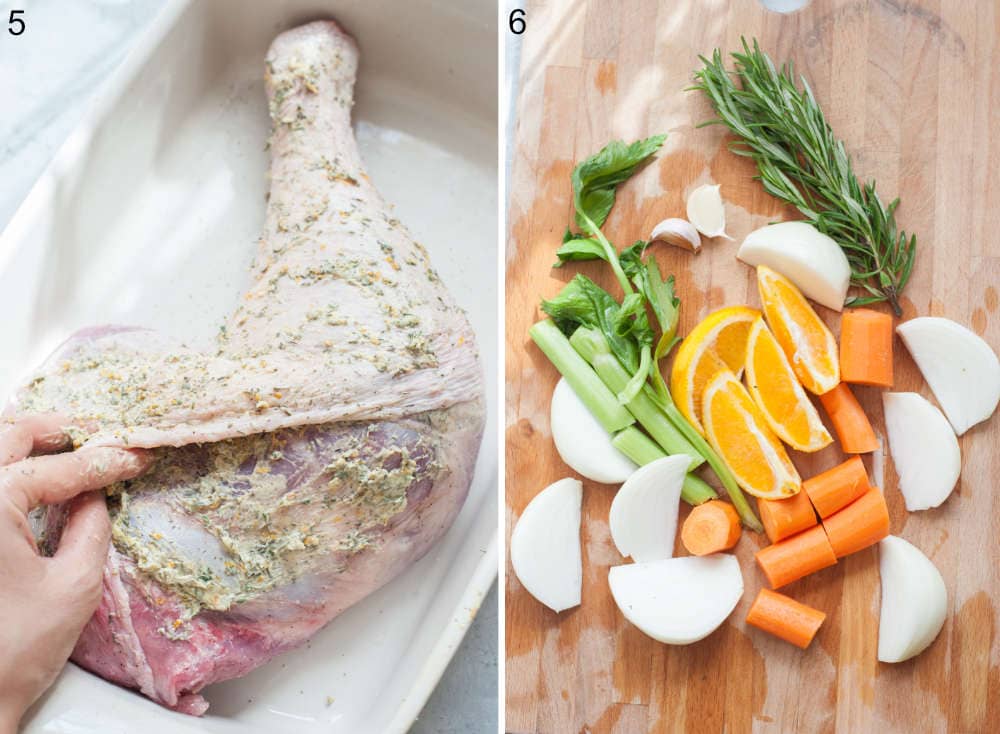 Turkey leg is being spread with herb butter. Chopped vegetables and herbs on a wooden board.