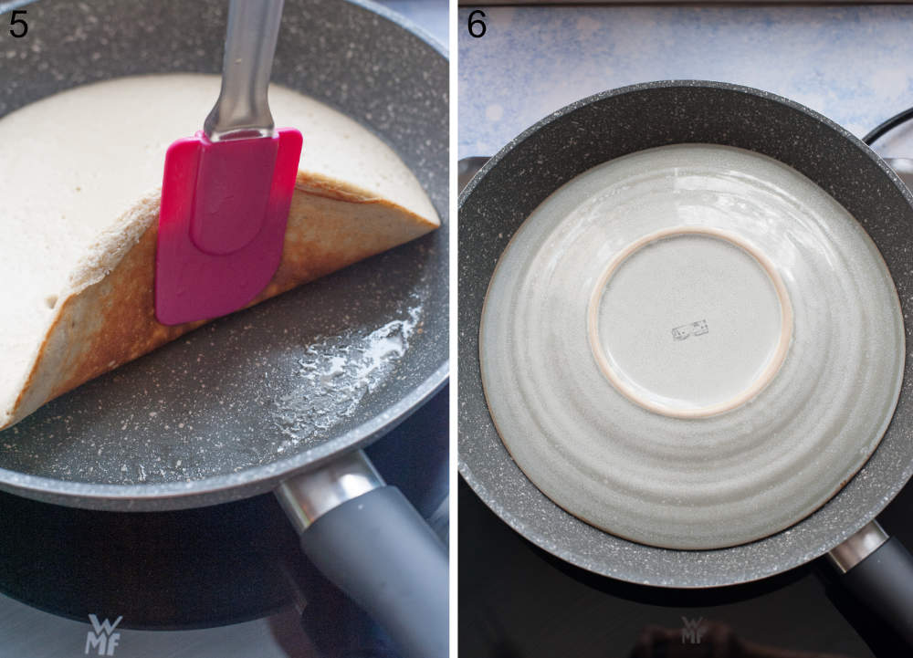 Omelette is being flipped with a spatula. A plate on top of a pan.