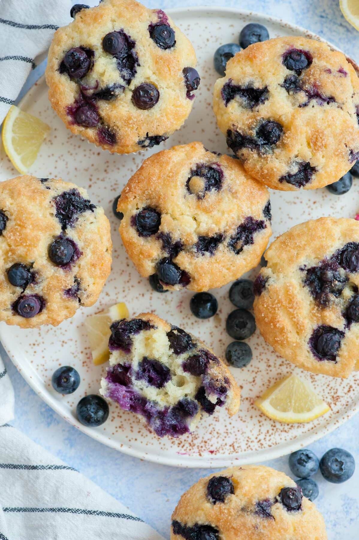 Overhead picture of blueberry yogurt muffins with one muffin cut in half.