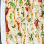Cottage cheese stuffed shells in a white baking dish.