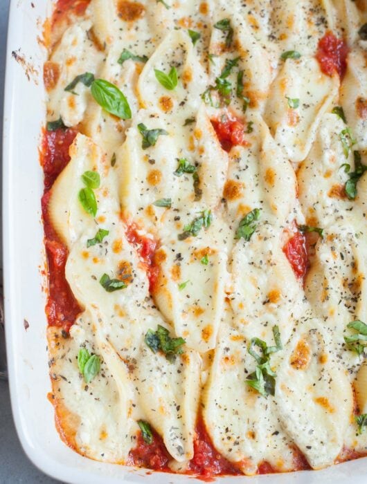 Cottage cheese stuffed shells in a white baking dish.