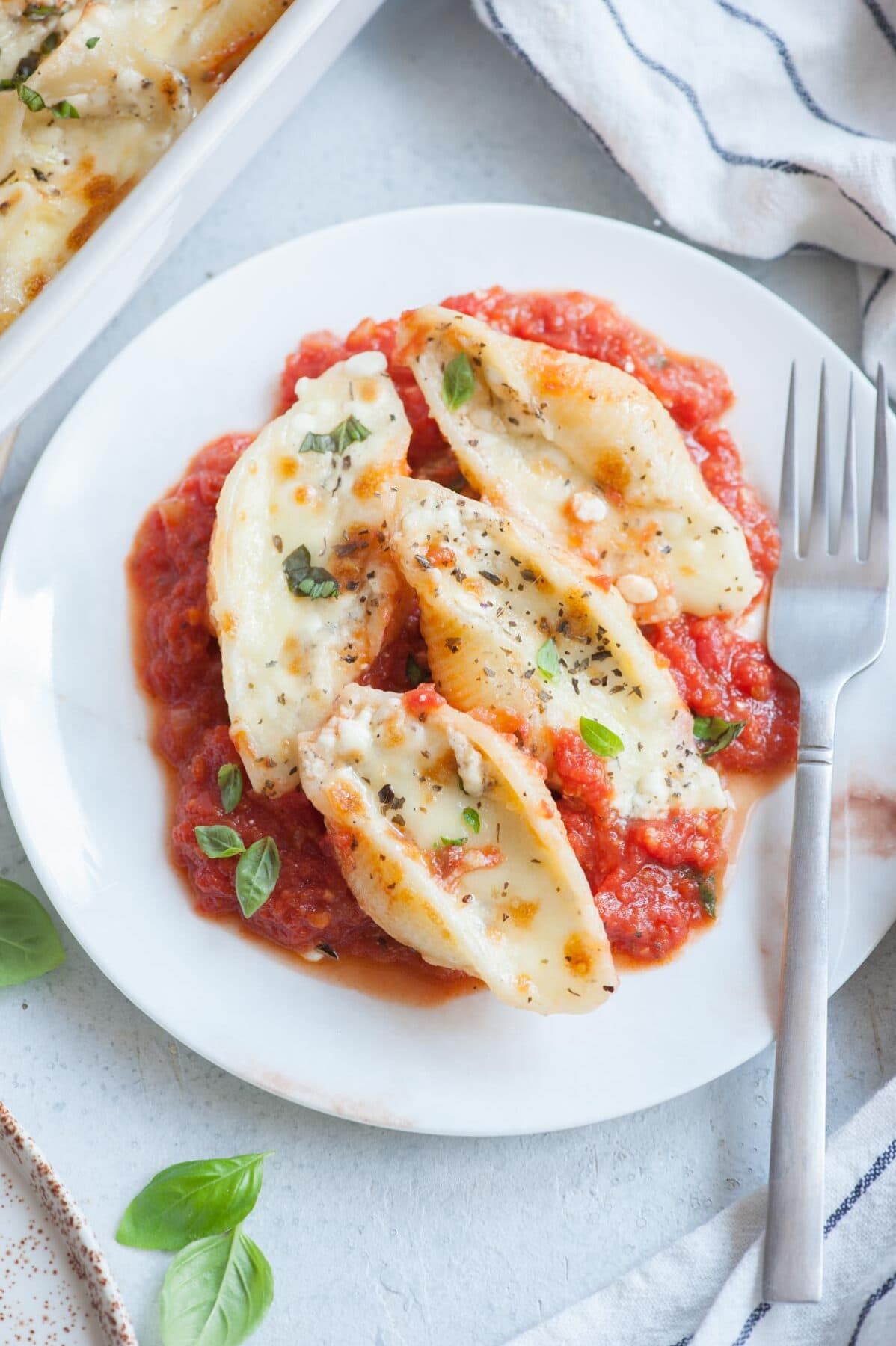 Close up picture of cottage cheese stuffed shells on a white plate.