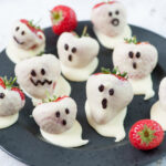 Strawberry ghosts on a black plate.