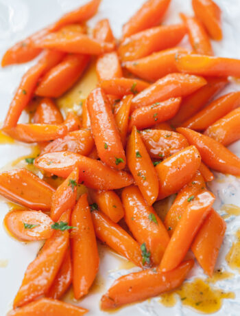 Honey glazed carrots on a white plate.