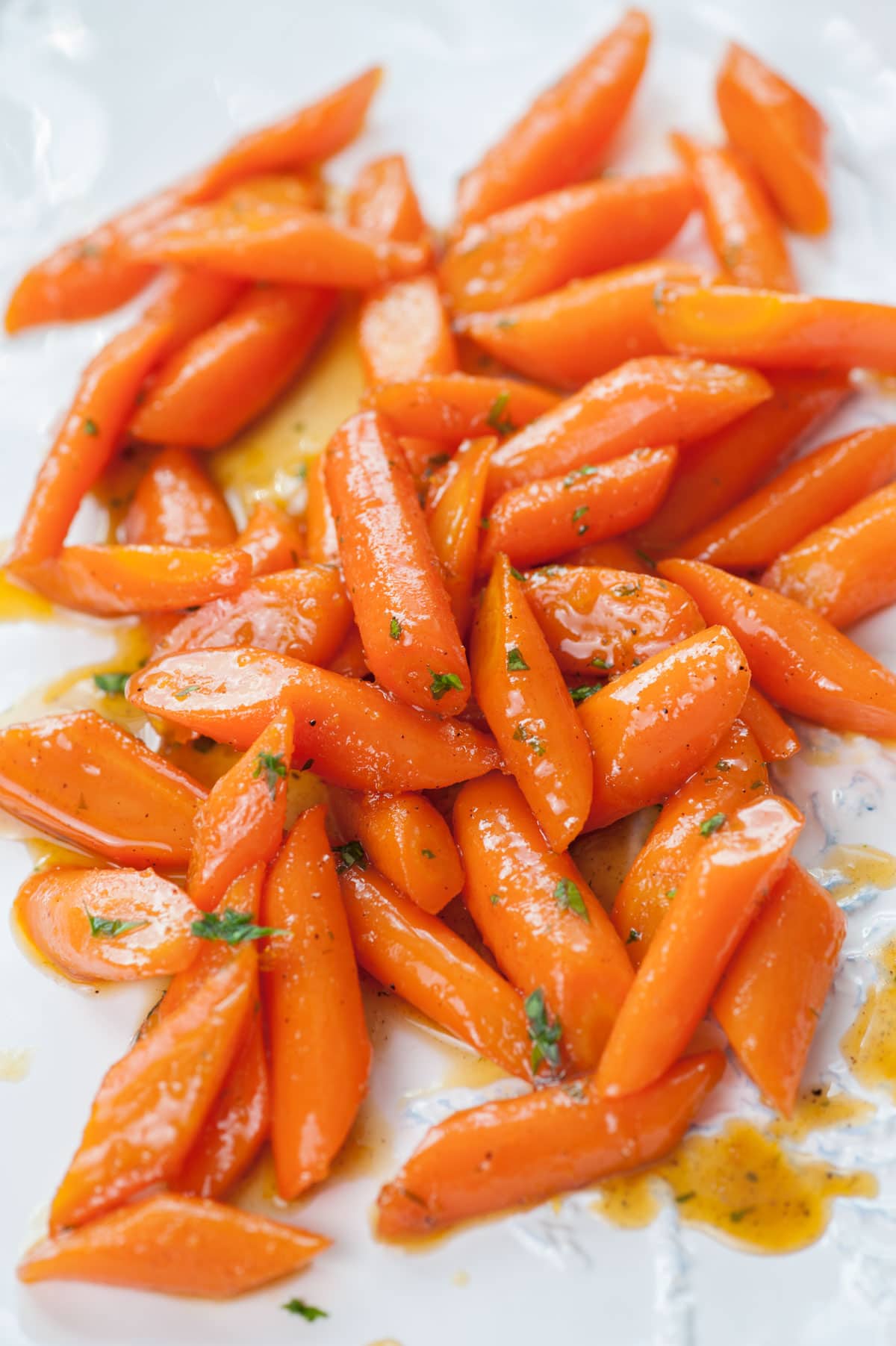 Honey glazed carrots on a white plate.