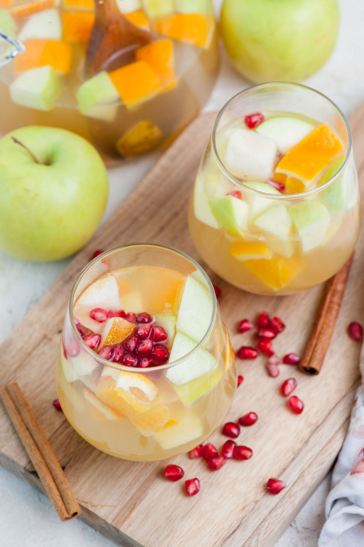 Two glasses with fall sangria on a wooden board.