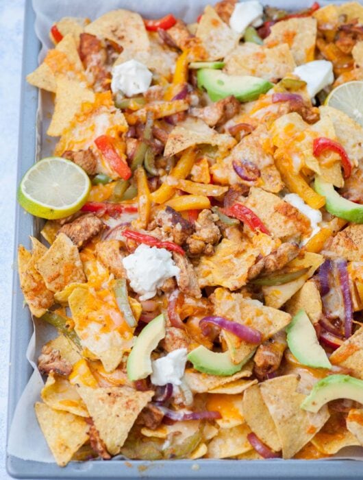 Chicken fajita nachos on a baking sheet.