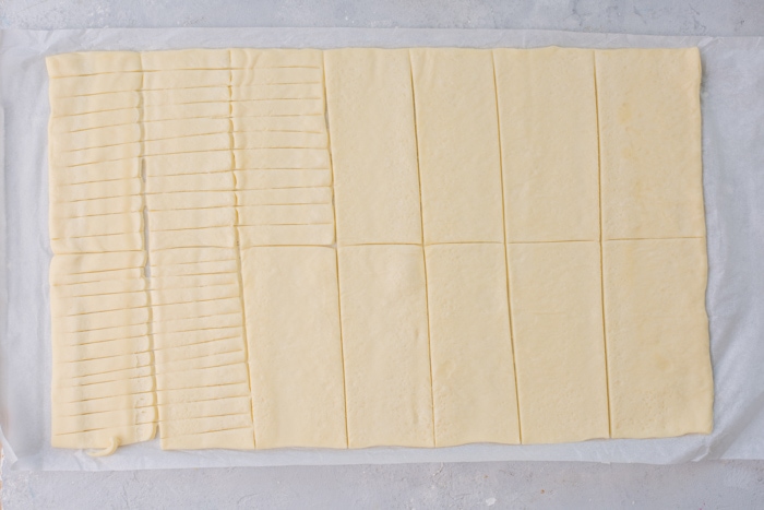 A pizza dough sheet cut into rectangles.