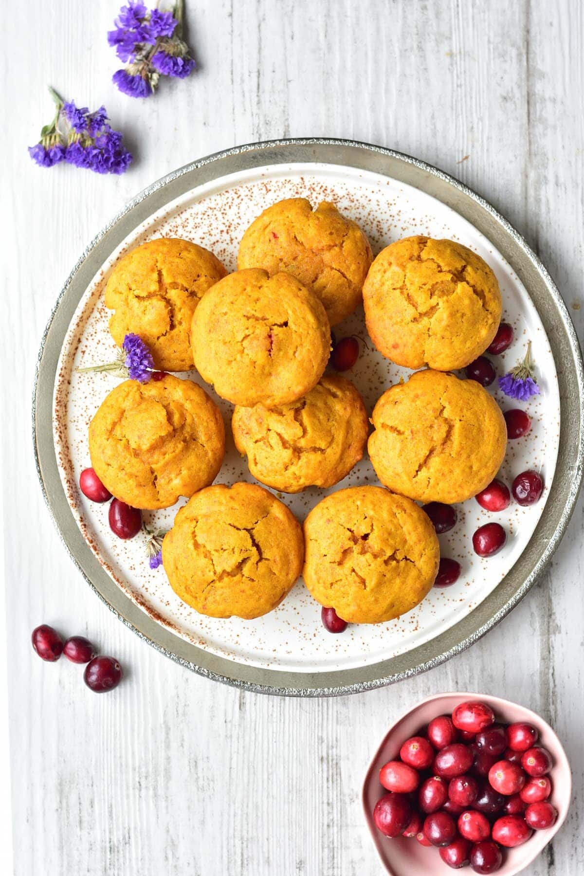 Overhead picture of pumpkin cranberry muffins on a white plate.