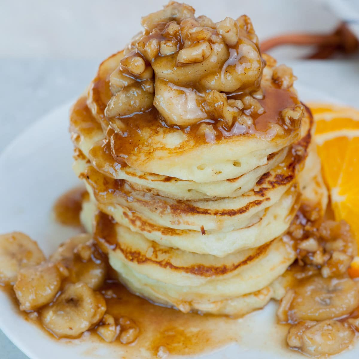 Bananas foster pancakes on a white plate.