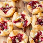 Cranberry brie bites on a wooden board.