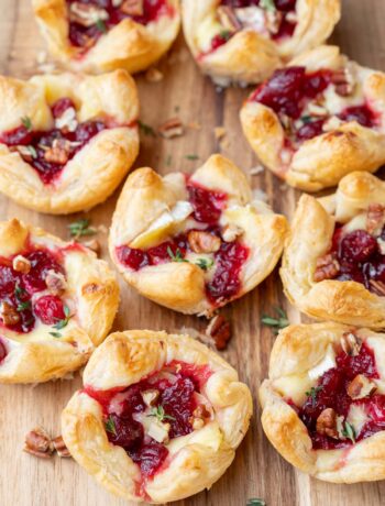 Cranberry brie bites on a wooden board.