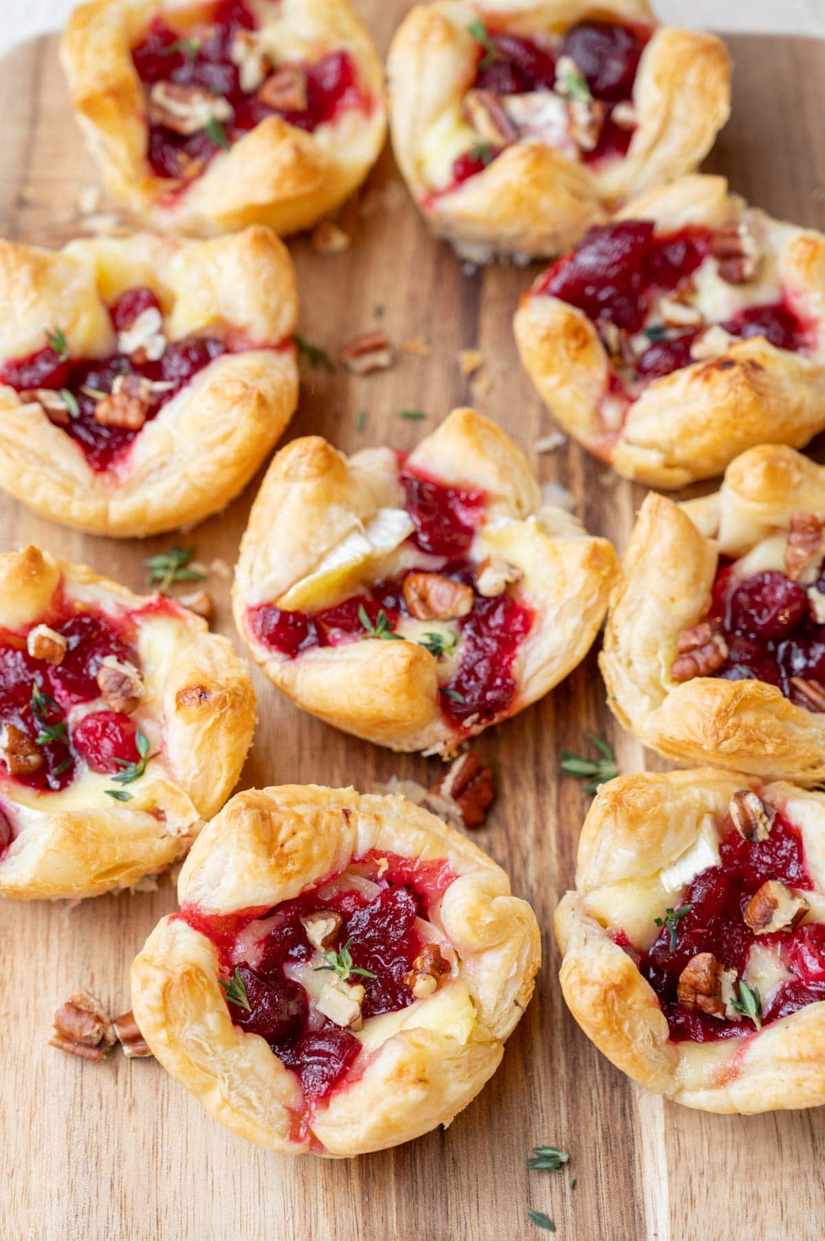 Cranberry brie bites on a wooden board.