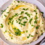 Cream cheese mashed potatoes in a beige bowl.