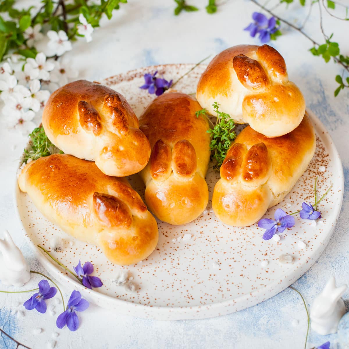 Easter rolls in form of bunnies on a white plate.
