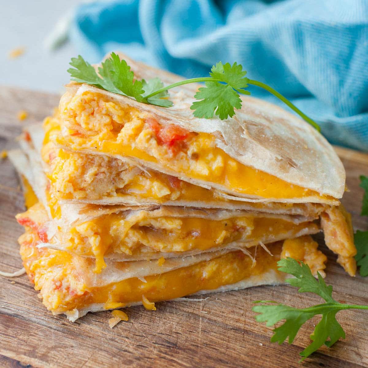 Scrambled eggs quesadillas on a wooden board.