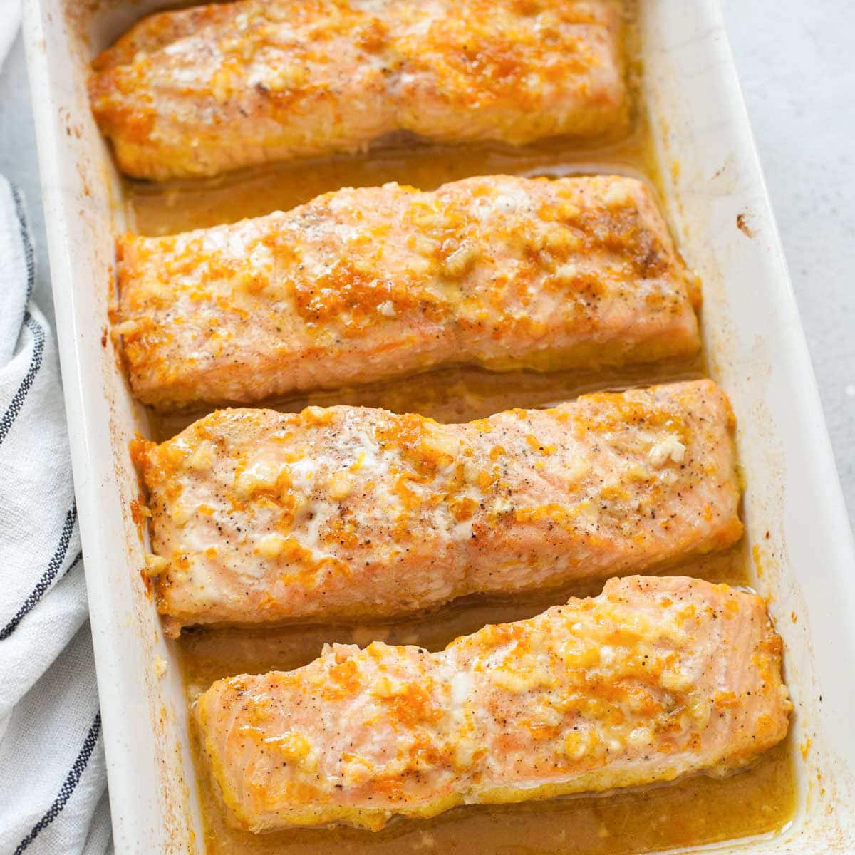 Maple orange salmon in a white baking dish.