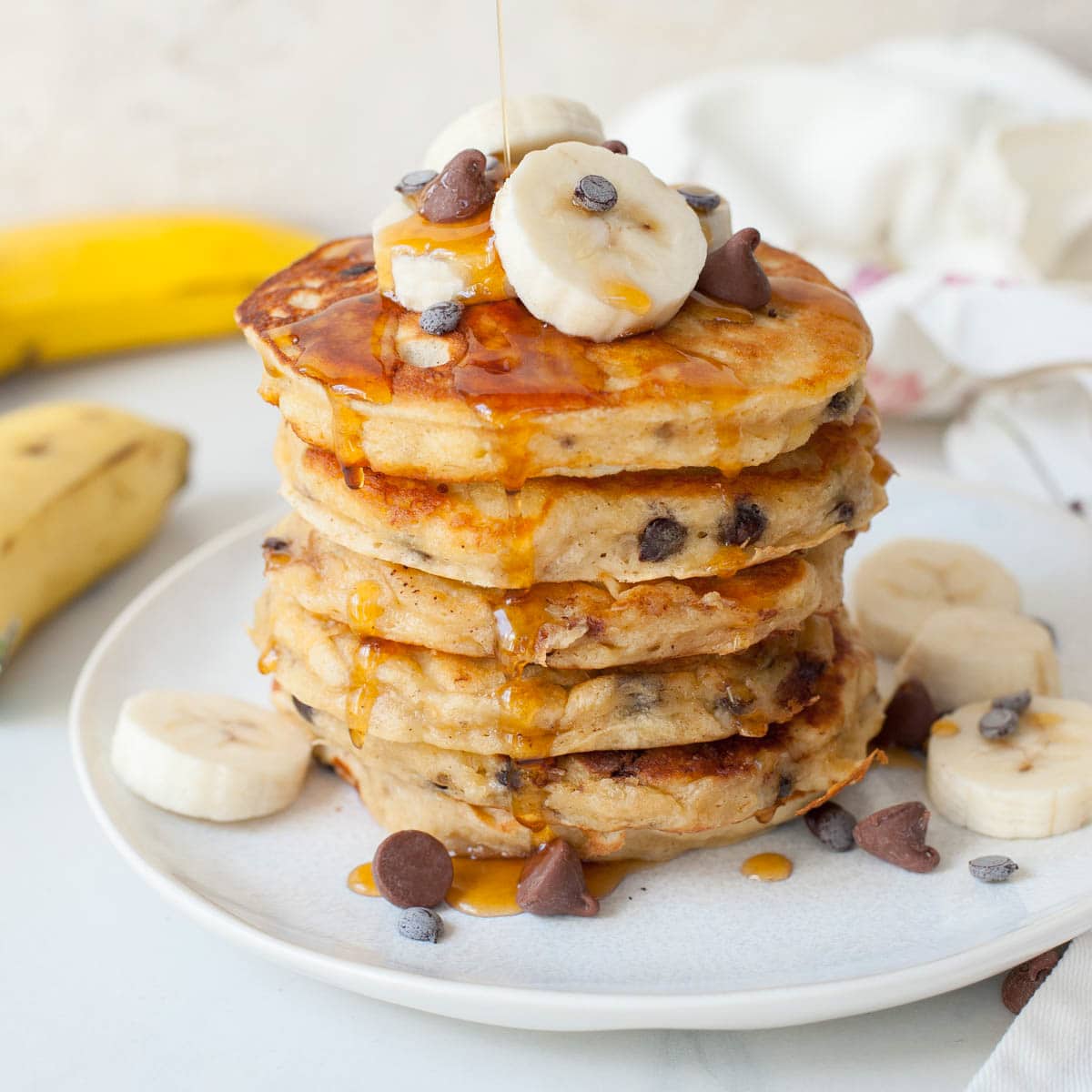 Banana chocolate chip pancakes on a white plate.