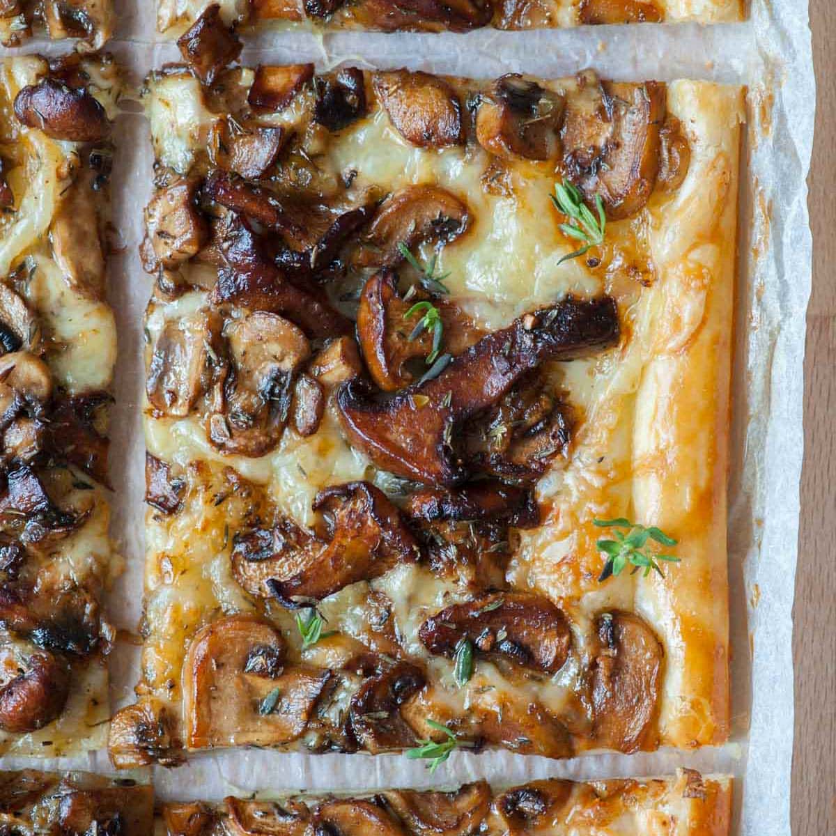 Puff pastry mushroom tart on a piece of parchment paper.