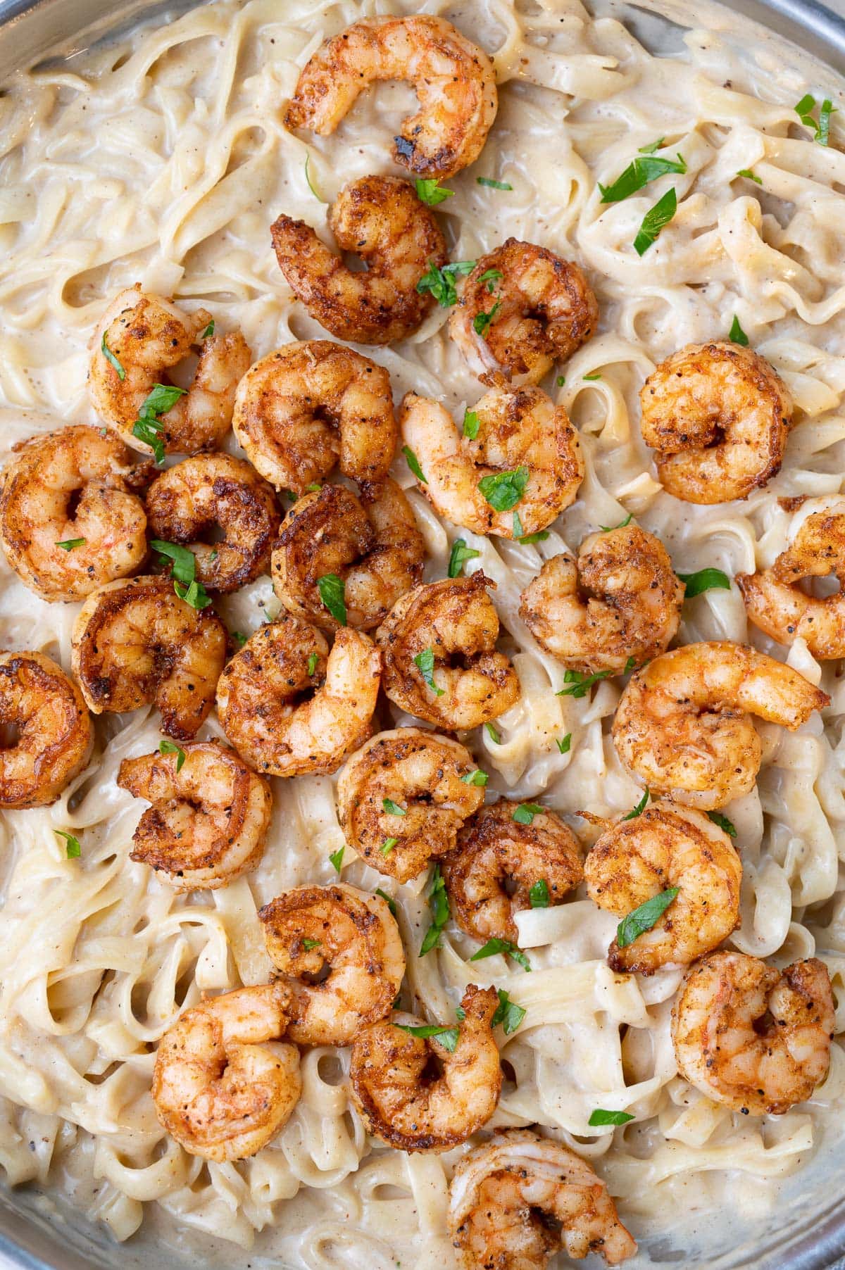 A close up picture of Cajun shrimp pasta in a frying pan.