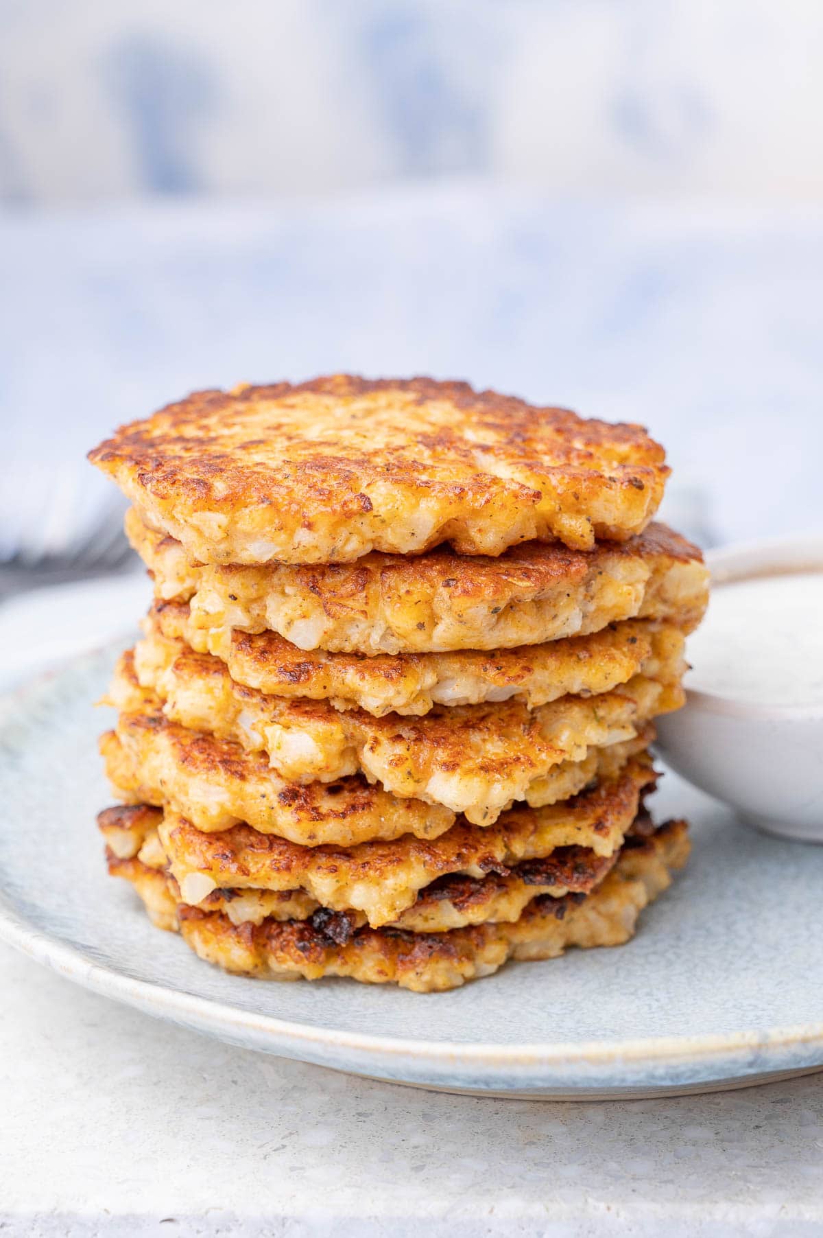 A stack of cauliflower fritters on a blue plate.