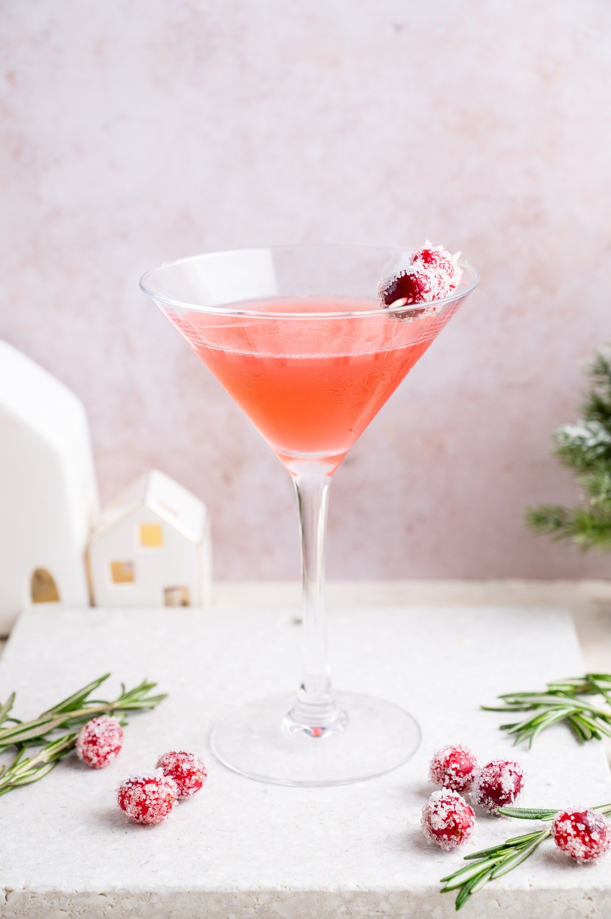 Cranberry martini in a martini glass decorated with sugared cranberries.