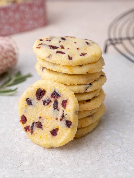 A stack of cranberry shortbread cookies on a grey stone board.