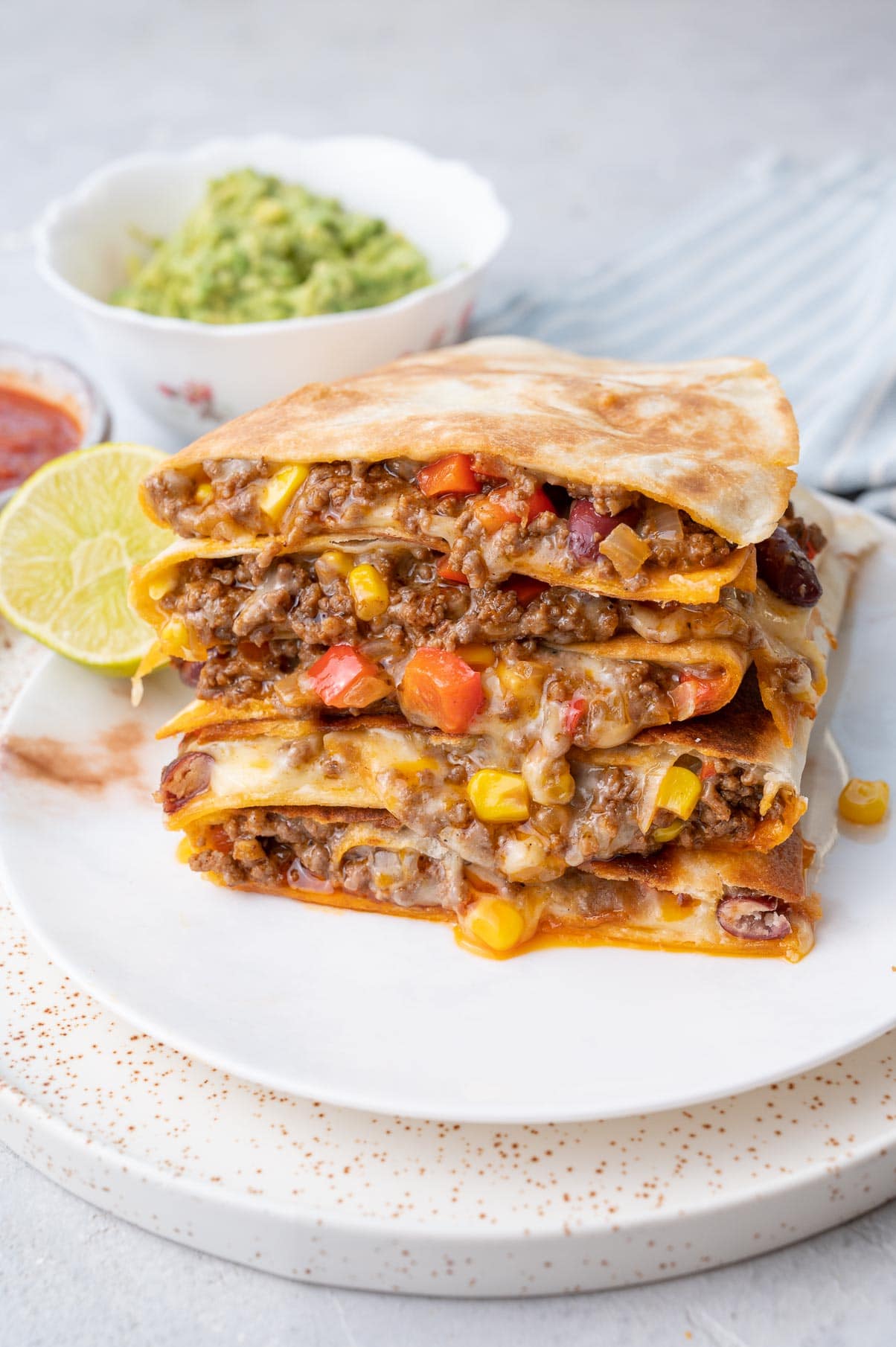 A stack of ground beef quesadillas on a white plate.