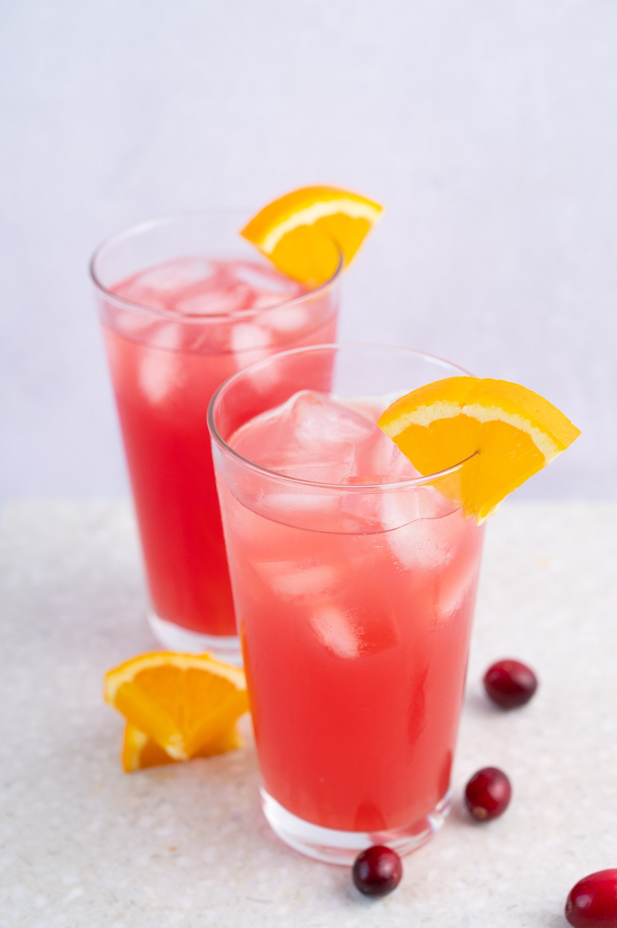 Два стакана с мадрасским напитком, украшенным дольками апельсина.
