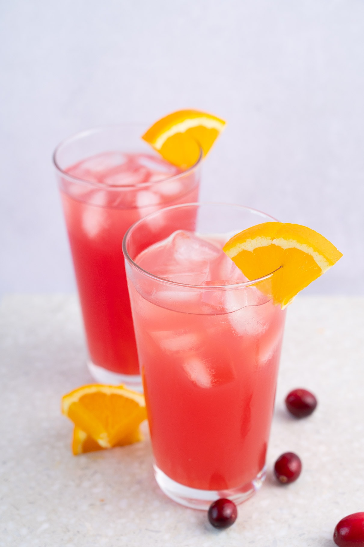 Two glasses with madras drink granished with orange slices.