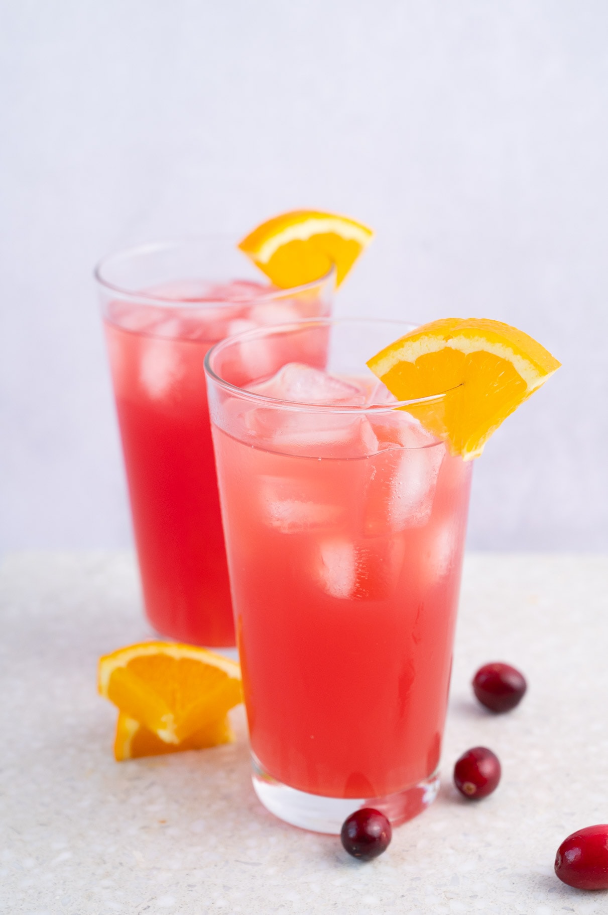 Two glasses with madras drink granished with orange slices.