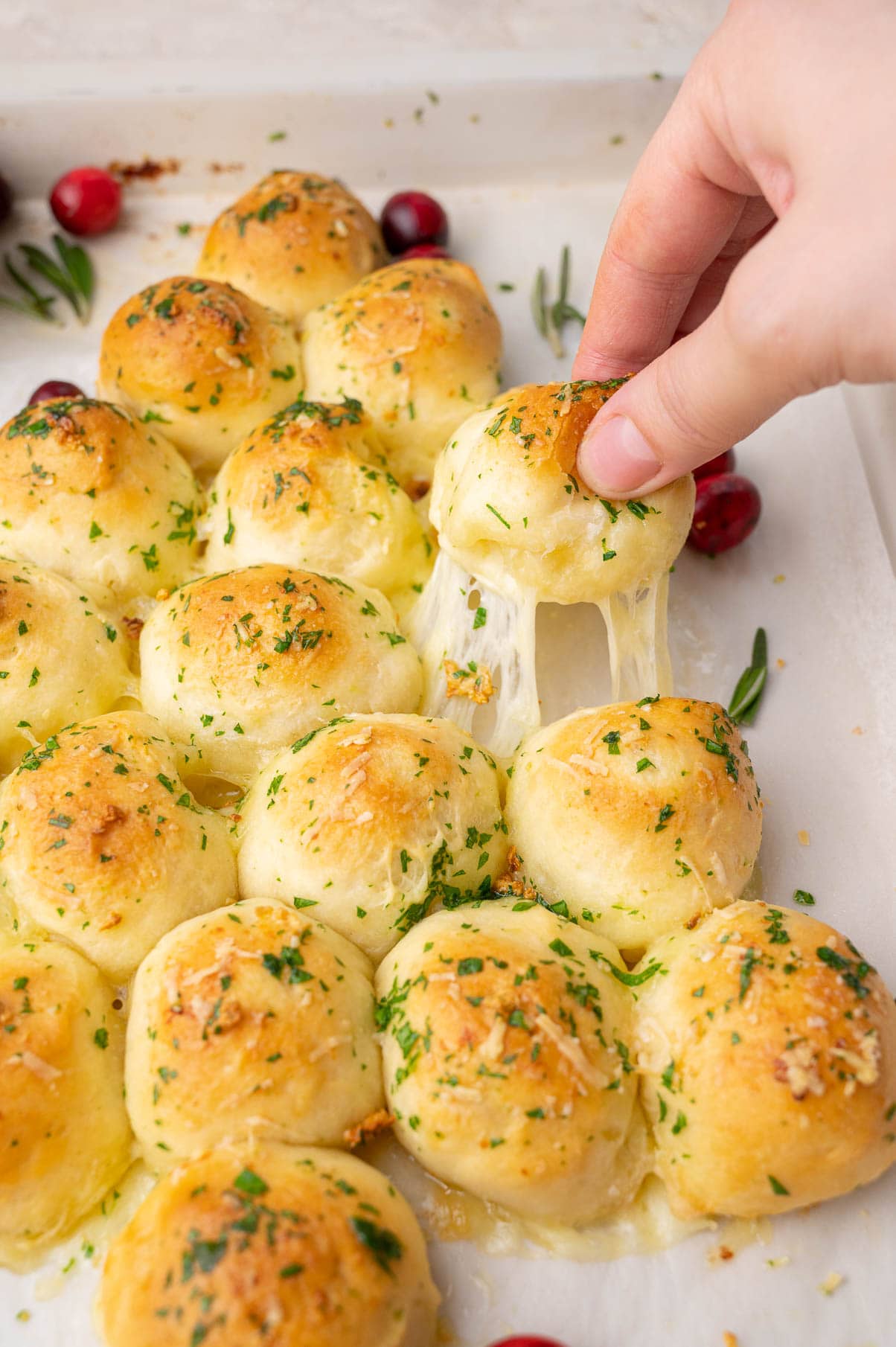 One pizza dough ball is being pulled from Christmas tree appetizer.