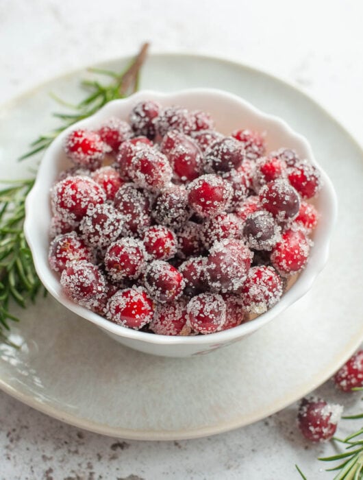 Sugared cranberries in a white bowl.