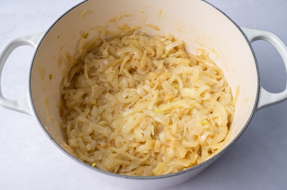 Sauteed onions in a white pot.