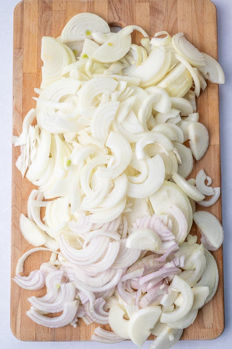 Sliced onions on a chopping board.