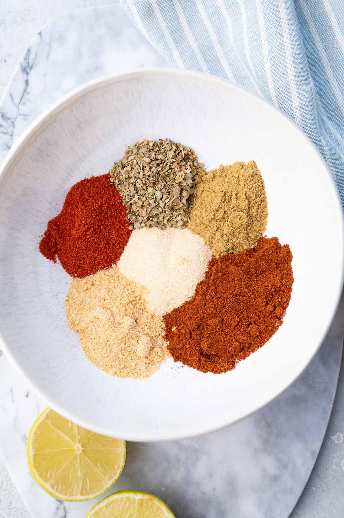 Ingredients for fajita seasoning in a white bowl.
