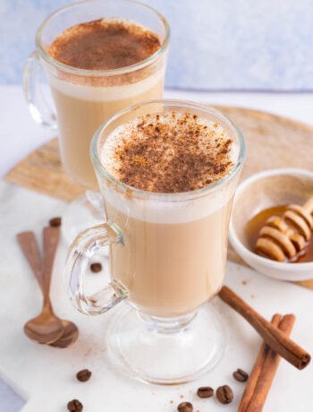 Two glasses with coffee with honey and cinnamon.