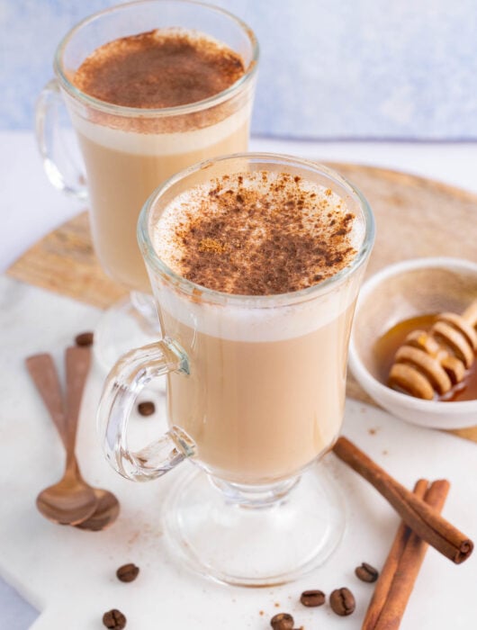 Two glasses with coffee with honey and cinnamon.