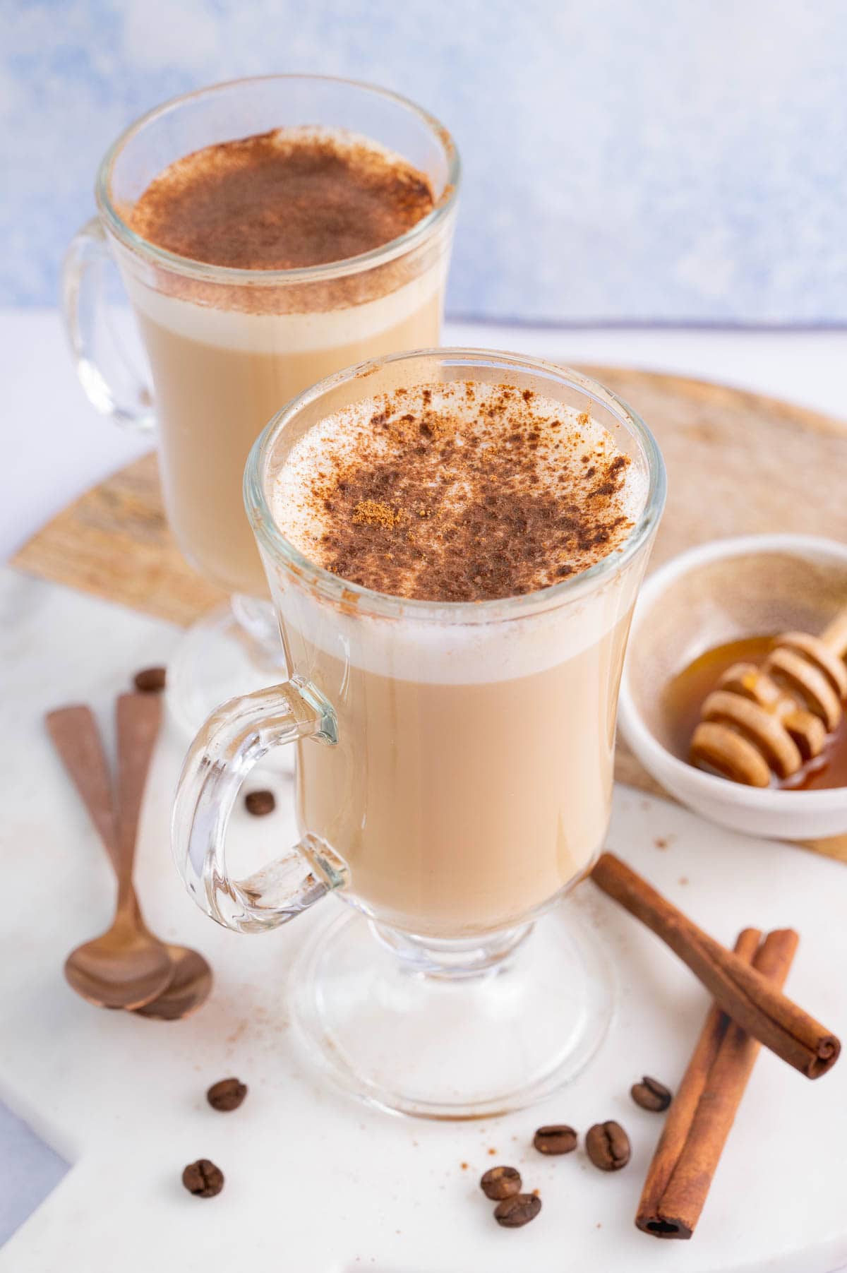 Two glasses with coffee with honey and cinnamon.