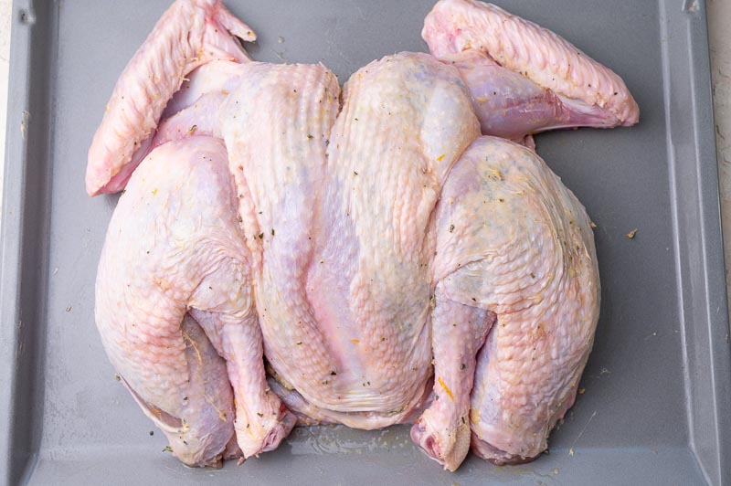 Ready to be baked spatchcock turkey on a baking sheet.